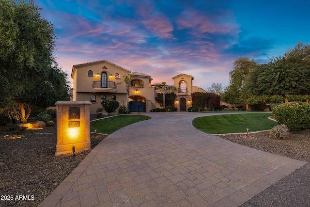 10894 E Turquoise Ave, Scottsdale, AZ 85259 - mediterranean / spanish house featuring a yard, curved driveway, a balcony, and stucco siding