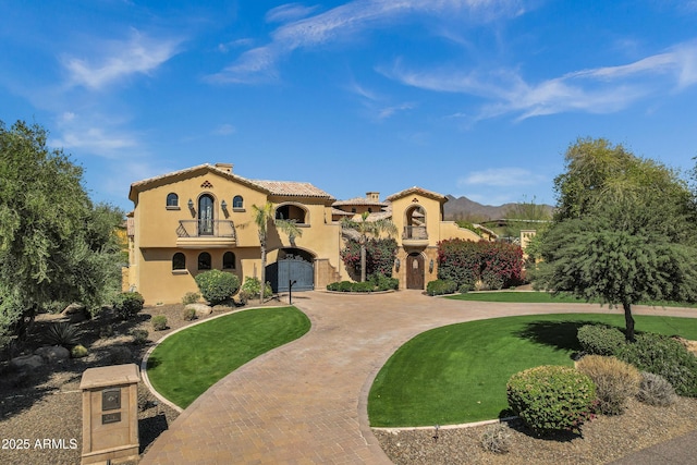 10894 E Turquoise Ave, Scottsdale, AZ 85259 - mediterranean / spanish-style home featuring stucco siding, a front lawn, curved driveway, a balcony, and a tiled roof