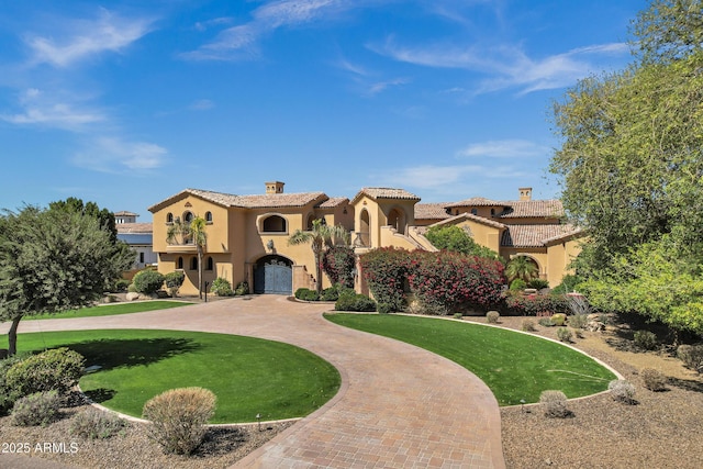 10894 E Turquoise Ave, Scottsdale, AZ 85259 - mediterranean / spanish house featuring stucco siding, a front lawn, curved driveway, a chimney, and a tiled roof