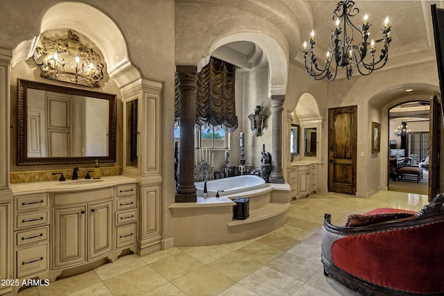 10894 E Turquoise Ave, Scottsdale, AZ 85259 - full bath with ornate columns, vanity, a bath, and an inviting chandelier