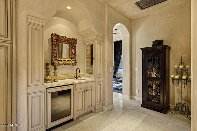10894 E Turquoise Ave, Scottsdale, AZ 85259 - bar featuring beverage cooler, a sink, arched walkways, light tile patterned floors, and wet bar