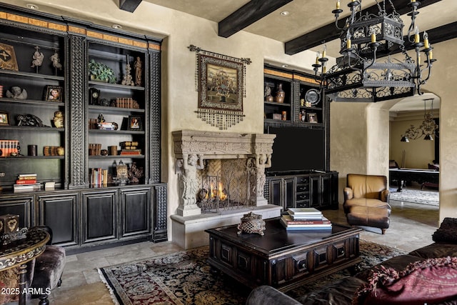 10894 E Turquoise Ave, Scottsdale, AZ 85259 - living room with beamed ceiling, built in features, stone tile flooring, arched walkways, and a fireplace
