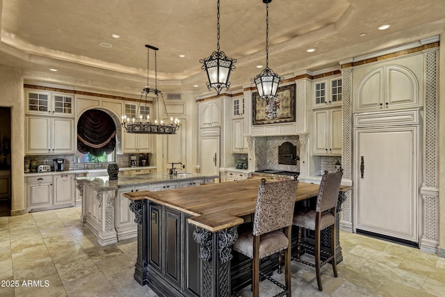 10894 E Turquoise Ave, Scottsdale, AZ 85259 - kitchen with a sink, a raised ceiling, an inviting chandelier, and a large island with sink