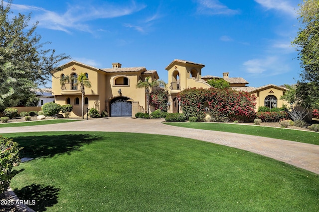 10894 E Turquoise Ave, Scottsdale, AZ 85259 - mediterranean / spanish-style home featuring a front yard, stucco siding, a tile roof, and curved driveway