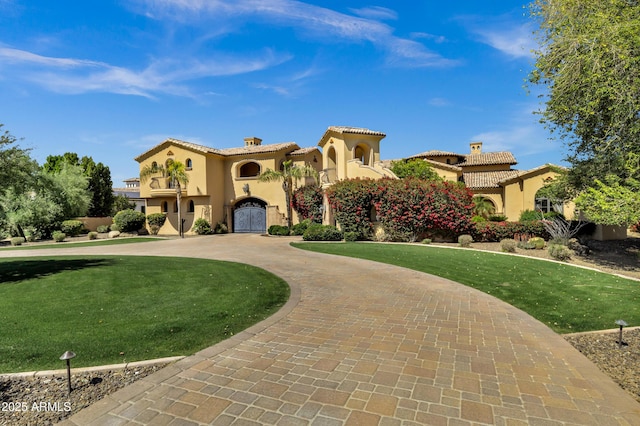 10894 E Turquoise Ave, Scottsdale, AZ 85259 - mediterranean / spanish-style home with curved driveway, a front lawn, a tile roof, stucco siding, and a chimney