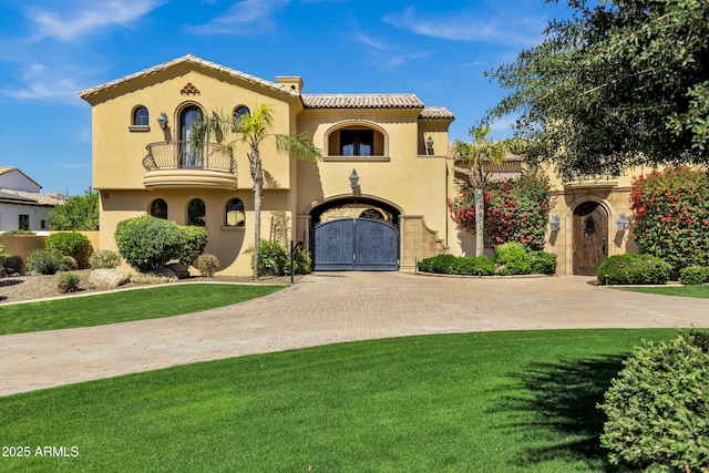 10894 E Turquoise Ave, Scottsdale, AZ 85259 - mediterranean / spanish-style home with stucco siding, a front lawn, a tile roof, a gate, and a balcony