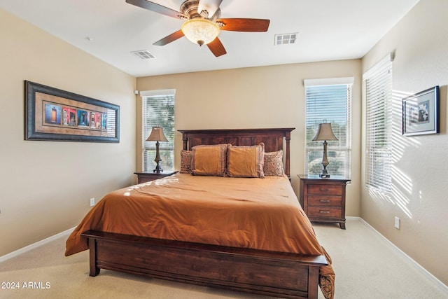 carpeted bedroom with multiple windows and ceiling fan