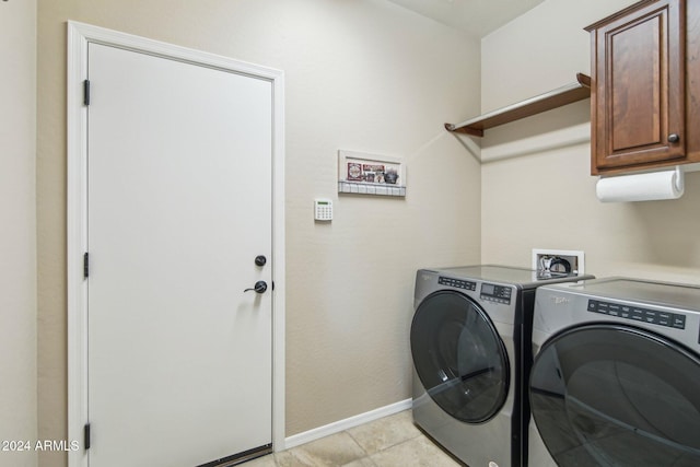 laundry area with cabinets, light tile patterned floors, and washer and clothes dryer