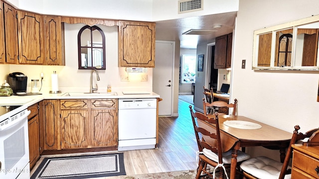 2064 S Farnsworth Dr Unit 38, Mesa, AZ 85209 - kitchen featuring white appliances, a sink, light wood-style floors, brown cabinets, and light countertops