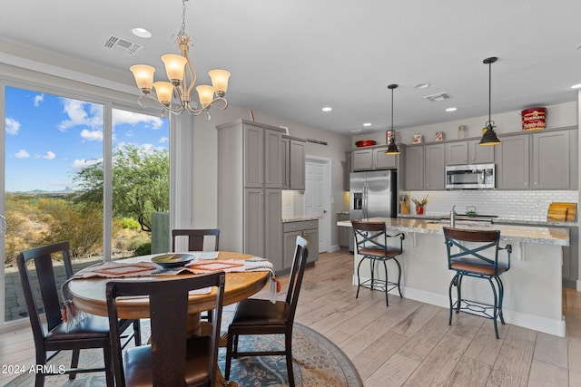 dining space featuring light wood finished floors, visible vents, a chandelier, and recessed lighting