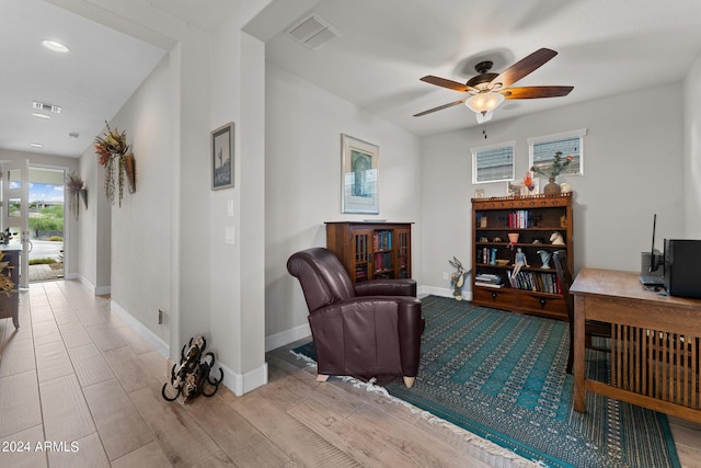 living area featuring visible vents, ceiling fan, and baseboards