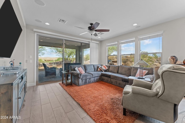 living area with visible vents, baseboards, ceiling fan, light wood-style floors, and recessed lighting