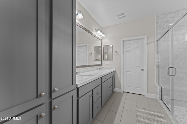 full bathroom with double vanity, a stall shower, visible vents, tile patterned flooring, and a sink