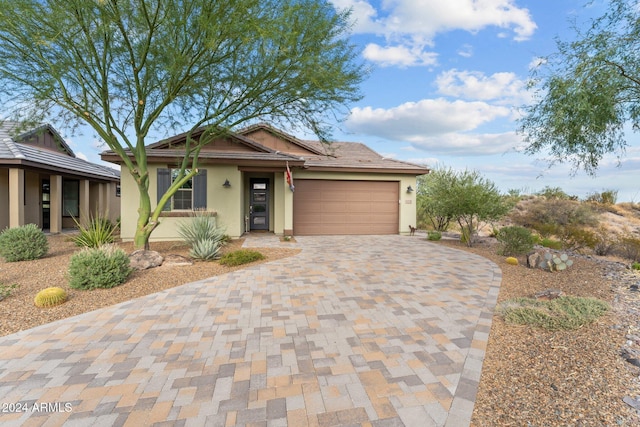 view of front of house featuring an attached garage, decorative driveway, and stucco siding