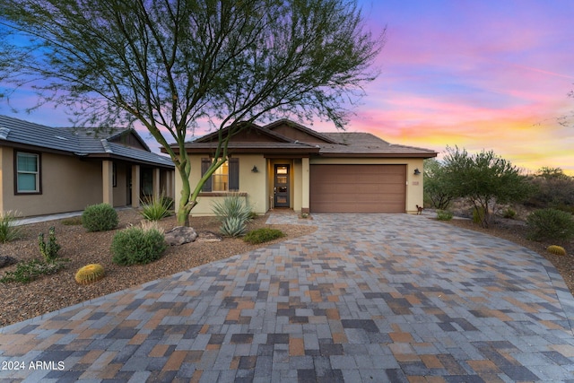 view of front of house with a garage, decorative driveway, and stucco siding