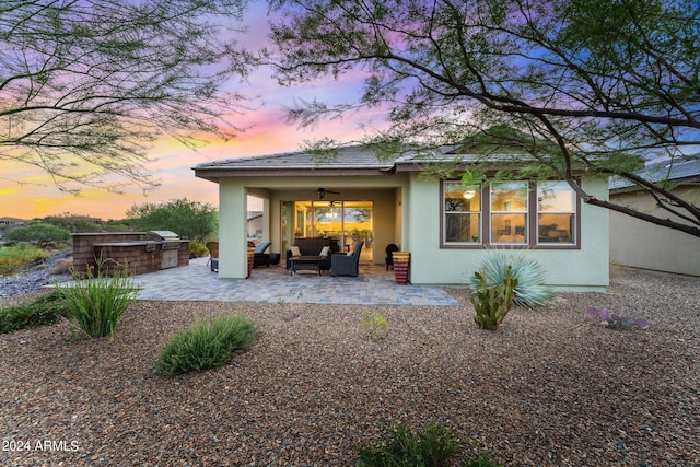 back of house featuring an outdoor hangout area, area for grilling, a ceiling fan, stucco siding, and a patio area