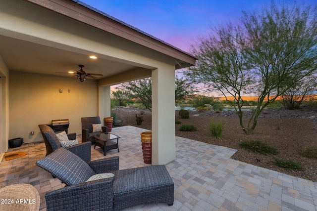 patio terrace at dusk featuring ceiling fan