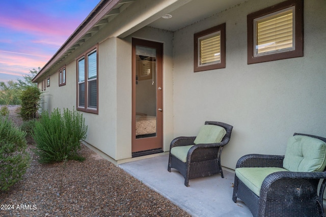 view of exterior entry with a patio and stucco siding