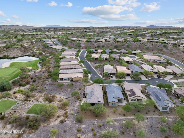 drone / aerial view featuring a residential view, view of golf course, and a water and mountain view