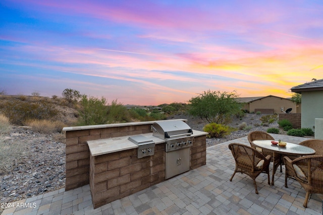 view of patio featuring outdoor dining area, grilling area, and exterior kitchen