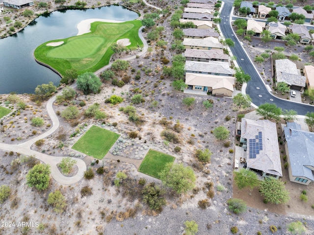 drone / aerial view with view of golf course, a water view, and a residential view