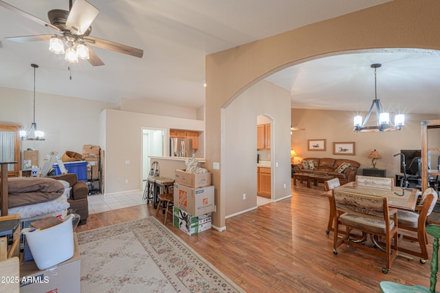 interior space with ceiling fan with notable chandelier and light hardwood / wood-style floors