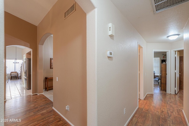 hallway with hardwood / wood-style flooring and a textured ceiling