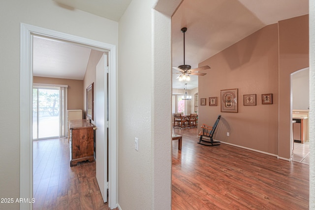 hall with lofted ceiling and hardwood / wood-style floors