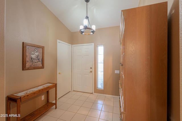 tiled foyer featuring lofted ceiling and a chandelier