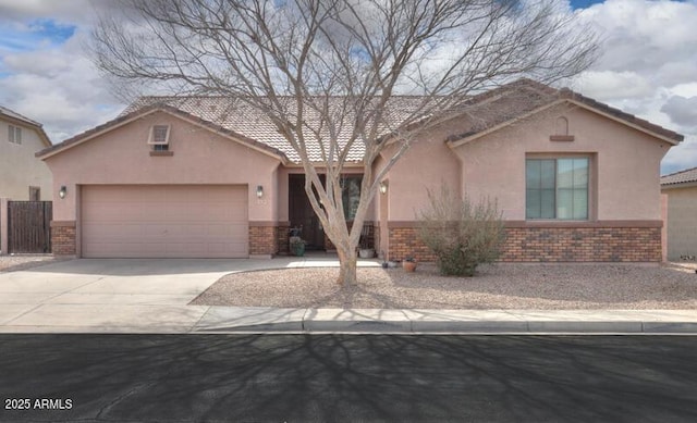 view of front facade featuring a garage, concrete driveway, brick siding, and stucco siding