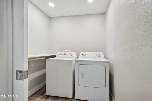 washroom with light hardwood / wood-style floors and separate washer and dryer