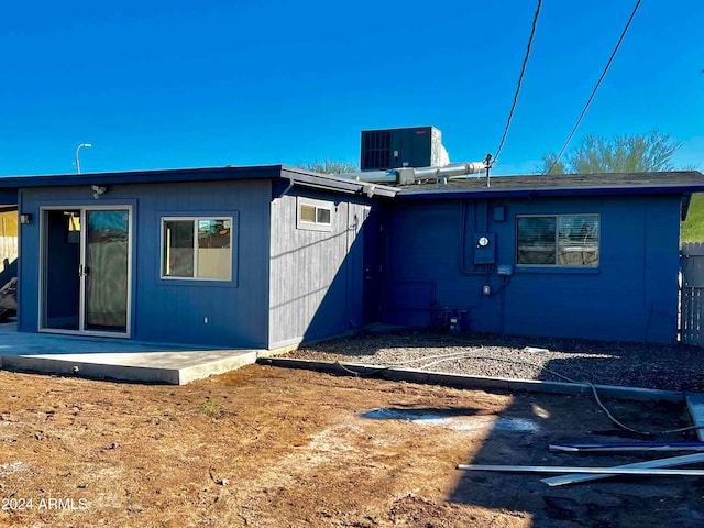 rear view of house with central air condition unit and a patio