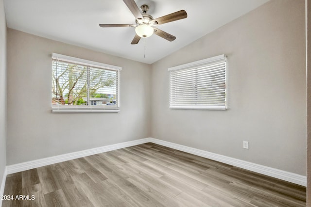 empty room featuring light wood-type flooring, vaulted ceiling, and ceiling fan