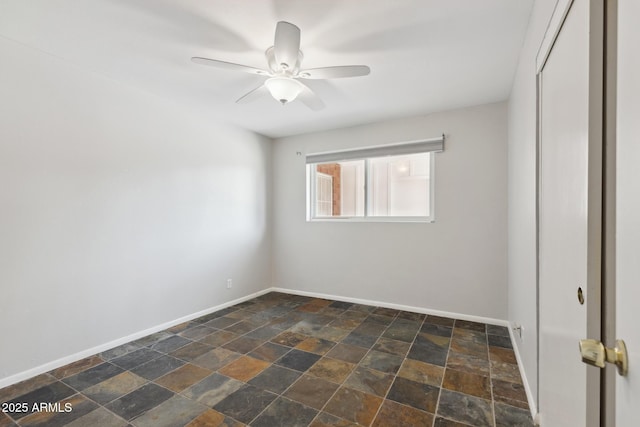 8301 E Indianola Ave, Scottsdale, AZ 85251 - spare room with ceiling fan, baseboards, and dark stone finish floors