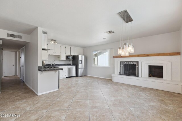 8301 E Indianola Ave, Scottsdale, AZ 85251 - kitchen featuring stainless steel appliances, dark countertops, light tile patterned floors, white cabinets, and a chandelier