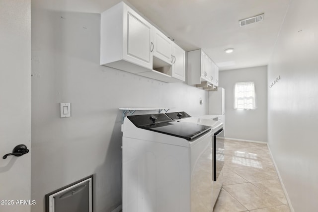 8301 E Indianola Ave, Scottsdale, AZ 85251 - laundry area with washing machine and dryer, cabinet space, baseboards, and light tile patterned floors