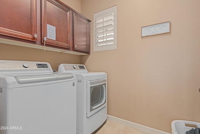 washroom featuring cabinets, independent washer and dryer, and light tile patterned floors