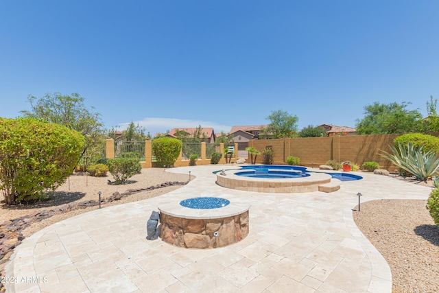 view of swimming pool featuring an in ground hot tub, an outdoor fire pit, and a patio area