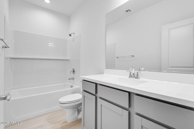 full bath with recessed lighting, toilet, vanity, wood finished floors, and  shower combination