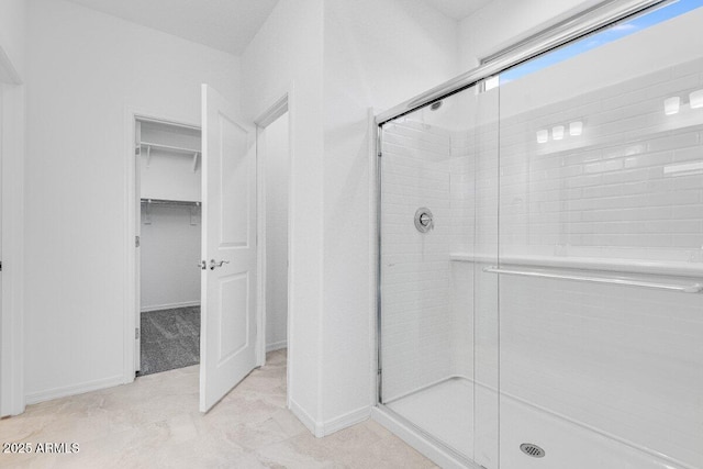 bathroom with a stall shower and a spacious closet