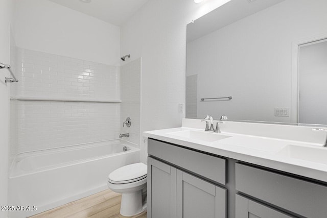 full bathroom featuring toilet, wood finished floors, a sink,  shower combination, and double vanity