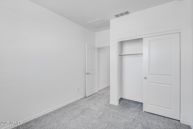 unfurnished bedroom with baseboards, a closet, visible vents, and carpet flooring