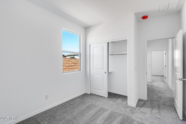 unfurnished bedroom with a closet, baseboards, visible vents, and carpet flooring