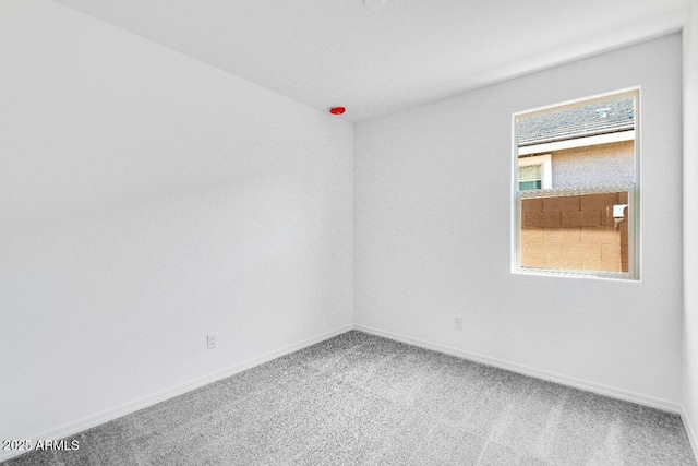 carpeted empty room with baseboards