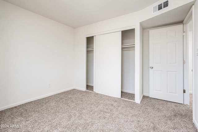 unfurnished bedroom with a closet and carpet flooring