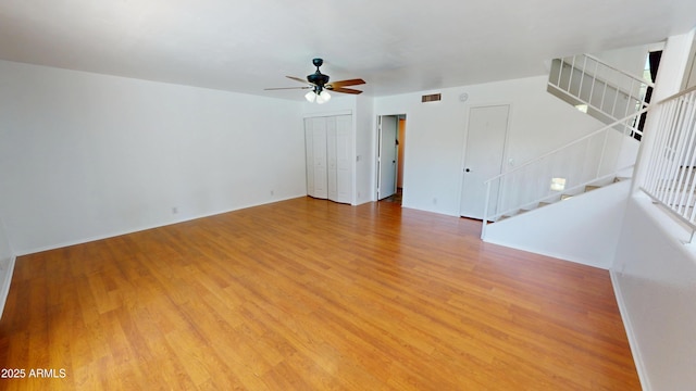 8541 W Pershing Ave, Peoria, AZ 85381 - empty room featuring a ceiling fan, stairs, and light wood-style flooring