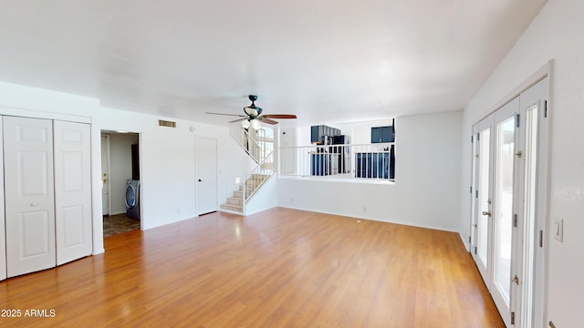 8541 W Pershing Ave, Peoria, AZ 85381 - unfurnished living room with light wood finished floors, a ceiling fan, stairs, and washer / clothes dryer
