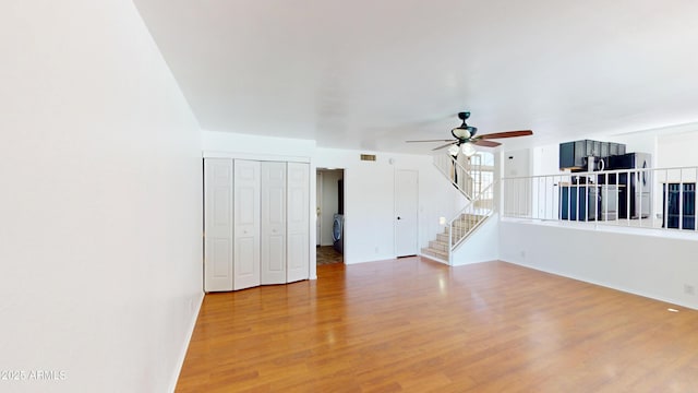 8541 W Pershing Ave, Peoria, AZ 85381 - unfurnished living room featuring ceiling fan, wood finished floors, stairs, and washer / clothes dryer