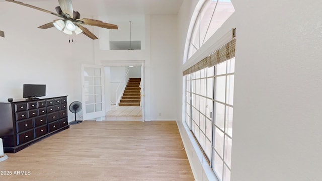 8541 W Pershing Ave, Peoria, AZ 85381 - unfurnished living room featuring a high ceiling, light wood finished floors, stairway, and a ceiling fan