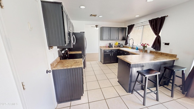 8541 W Pershing Ave, Peoria, AZ 85381 - kitchen featuring a peninsula, a kitchen bar, recessed lighting, light countertops, and light tile patterned floors